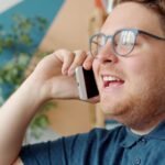 Personne au téléphone avec un agent vocal IA Fonixia - installateurs panneaux solaires